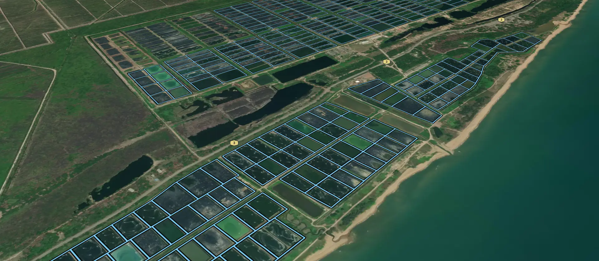 Shrimp ponds along a coastline, each outlined in blue on satellite imagery in AquaScape